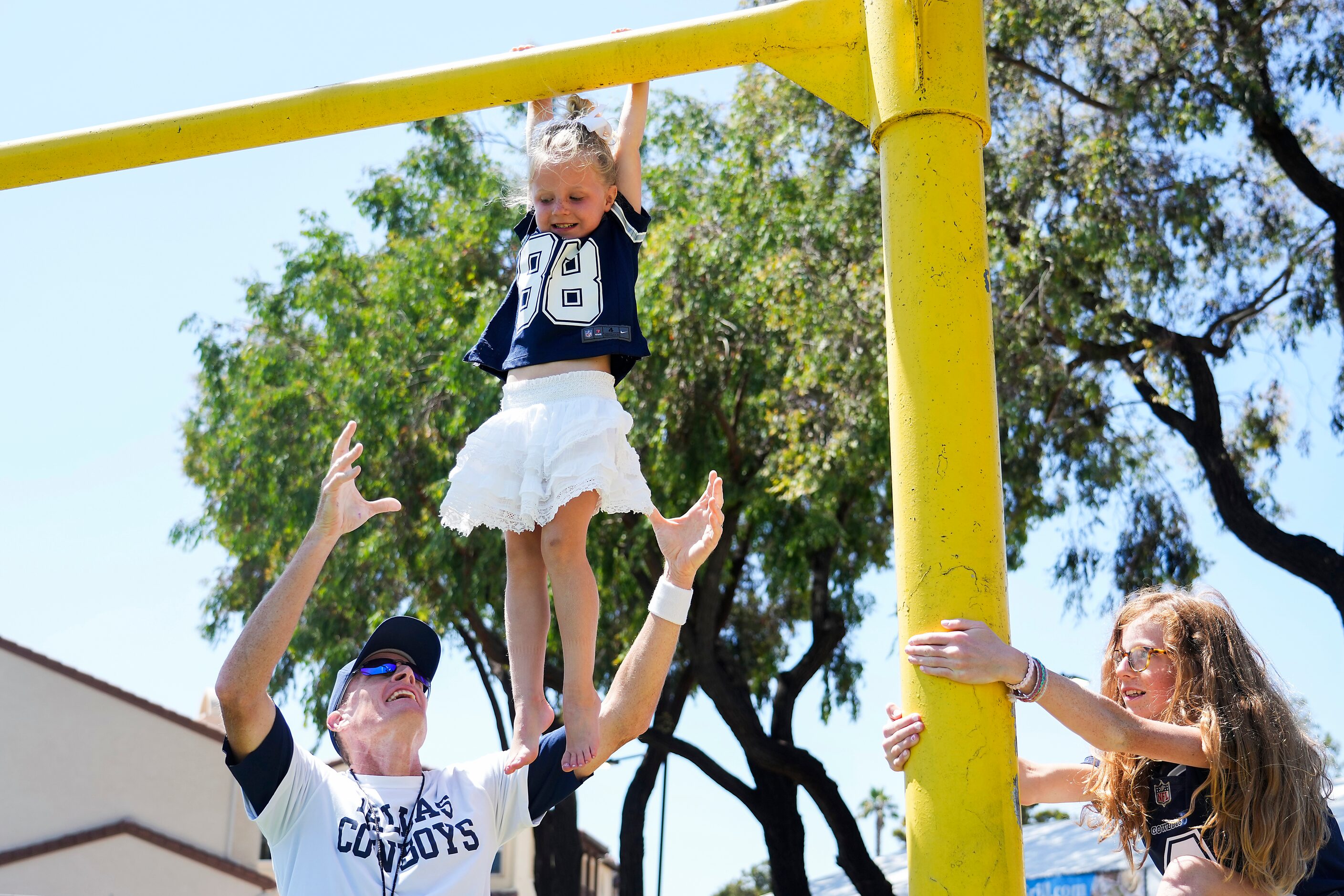 Dallas Cowboys special teams coordinator John Fassel lifts up his daughter Anna, 4, as...