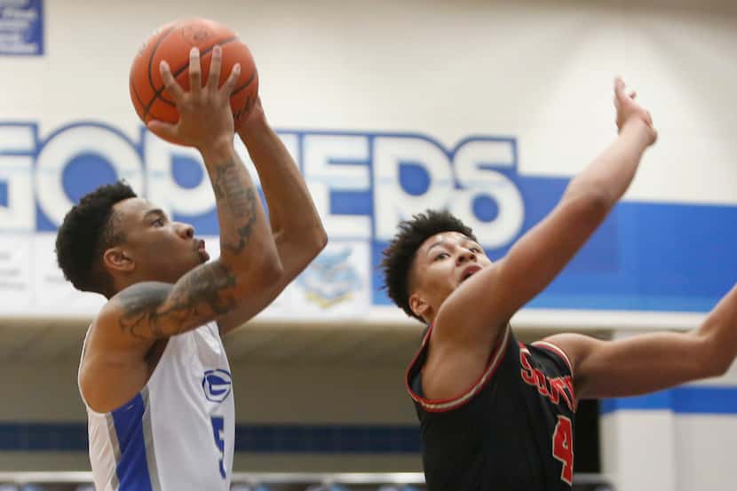 Grand Prairie's Donovan Newton (left) drives to the basket as he is defended by South Grand...