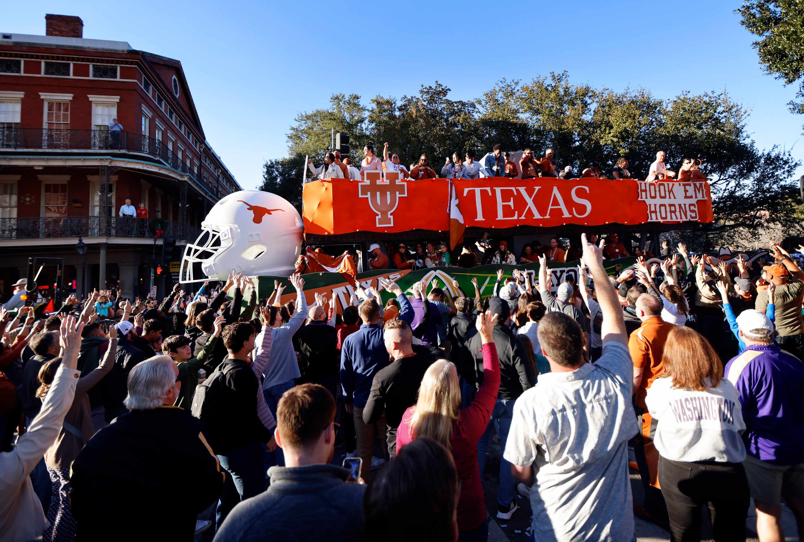 Texas Longhorns fans throw beads from atop a large float during the Mardi Gras-style...