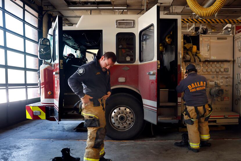 Dallas Fire and Rescue Captain Cristian Hinojosa (left) prepares to head out on a call with...