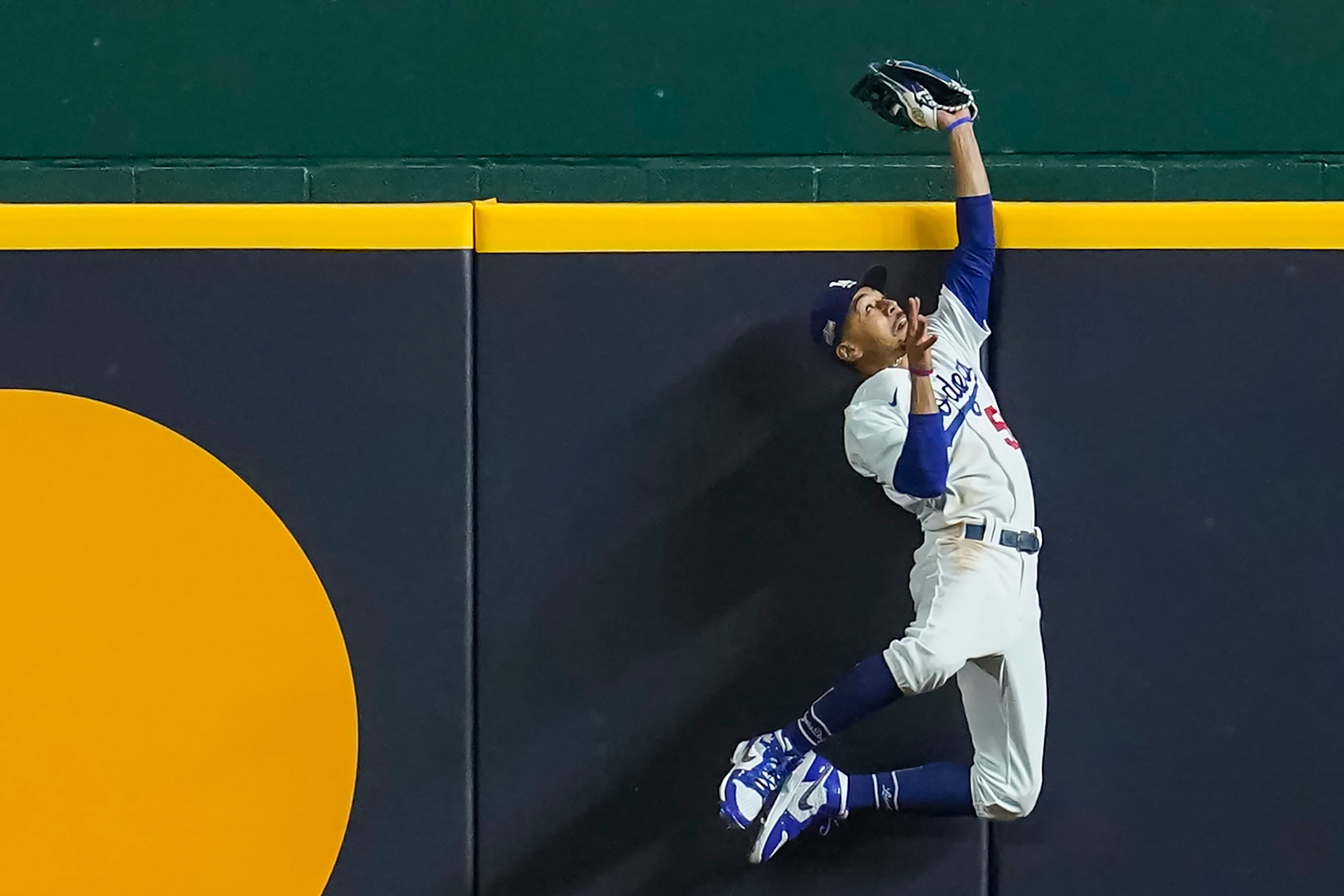 Los Angeles Dodgers right fielder Mookie Betts makes a leaping catch at the wall to take a...