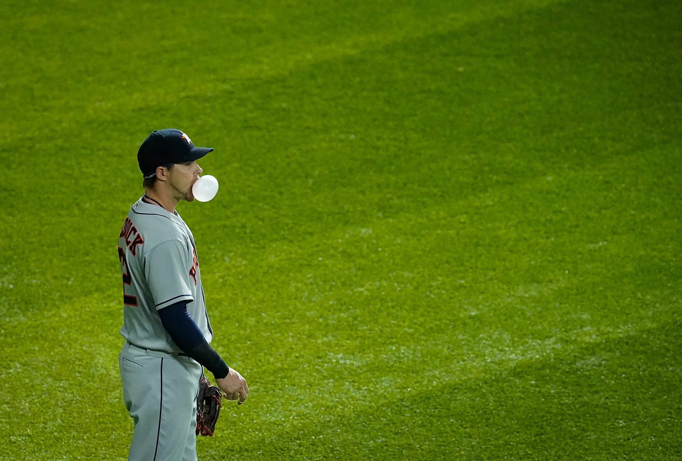 Houston Astros right fielder Josh Reddick blows bubbles in the outfield during the second...