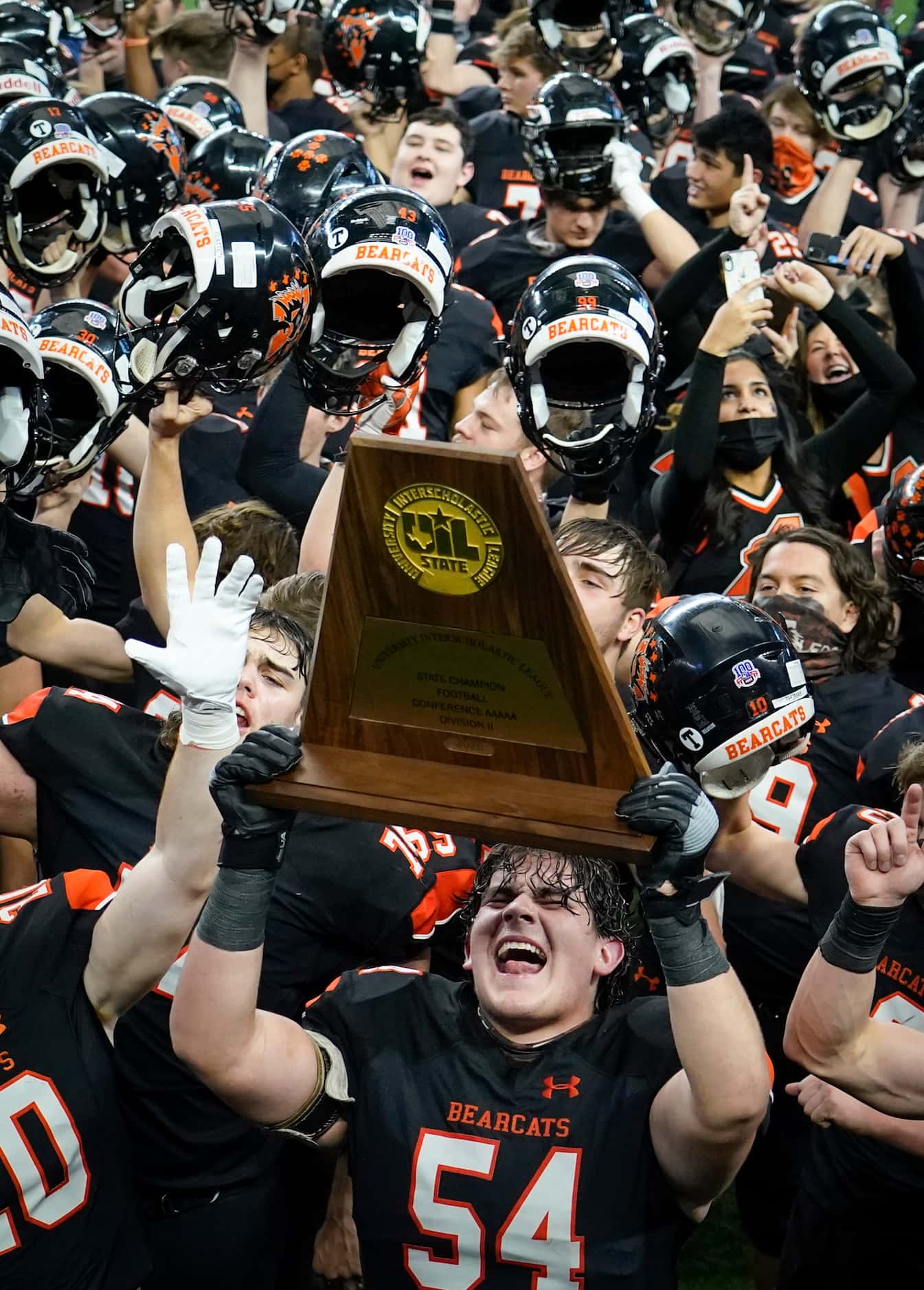 Aledo offensive lineman Rocco O'Keefe (54) hoists the championship trophy as the Bearcats ...