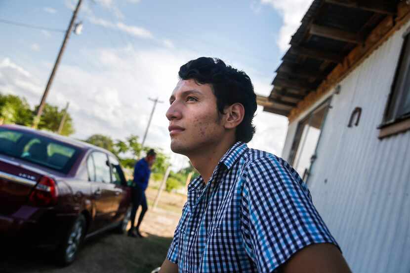 Francisco Galicia waits outside his family's home as a television journalist sets up a...