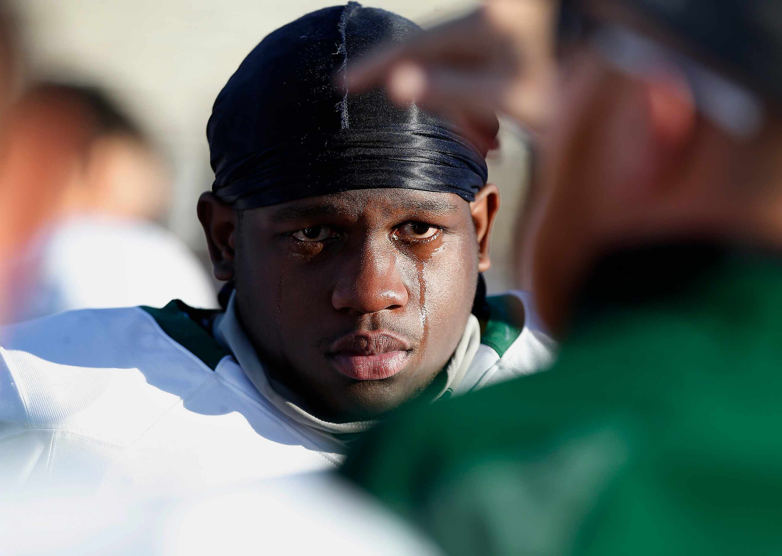 Prosper High School linebacker Jordan Johnson (47) realizes his season is over as he listens...