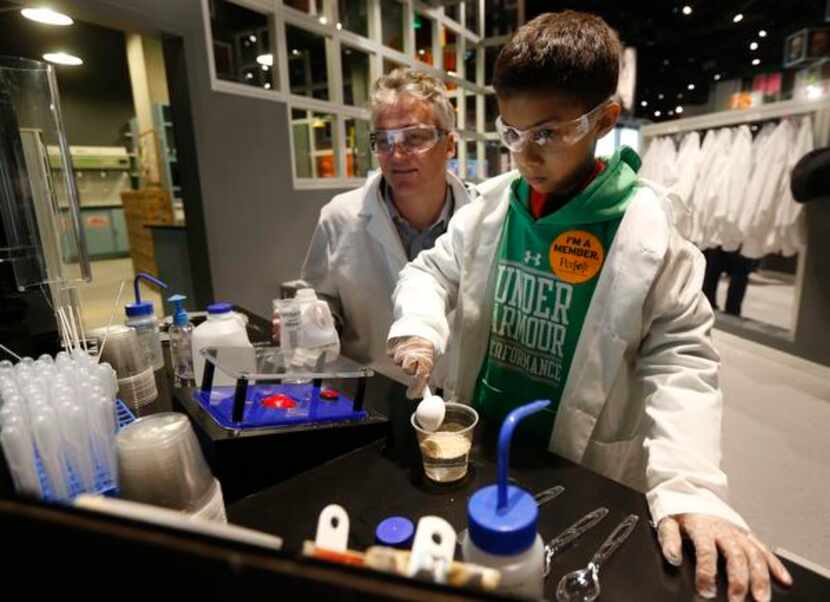 
Jost Flender, left, and Caiden Trivedi, 9, of Switzerland learn about DNA while doing an...