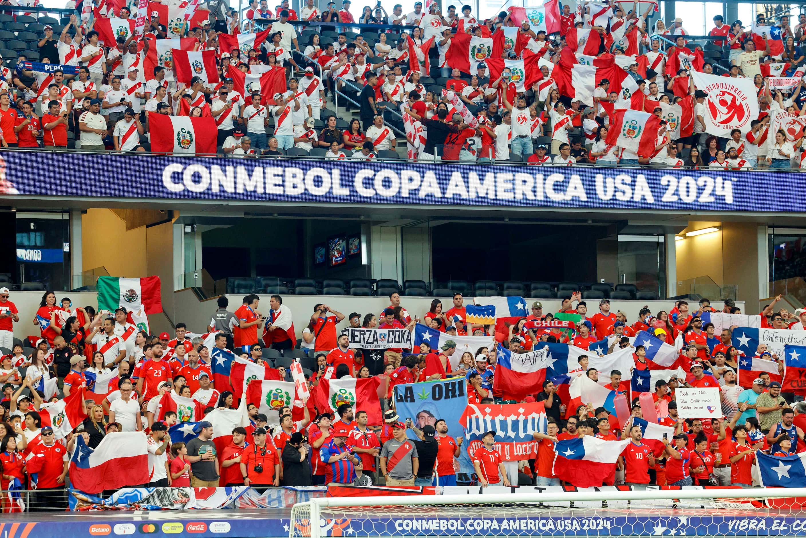 Chile and Peru soccer fans stand and cheer as the players take the field before a Copa...