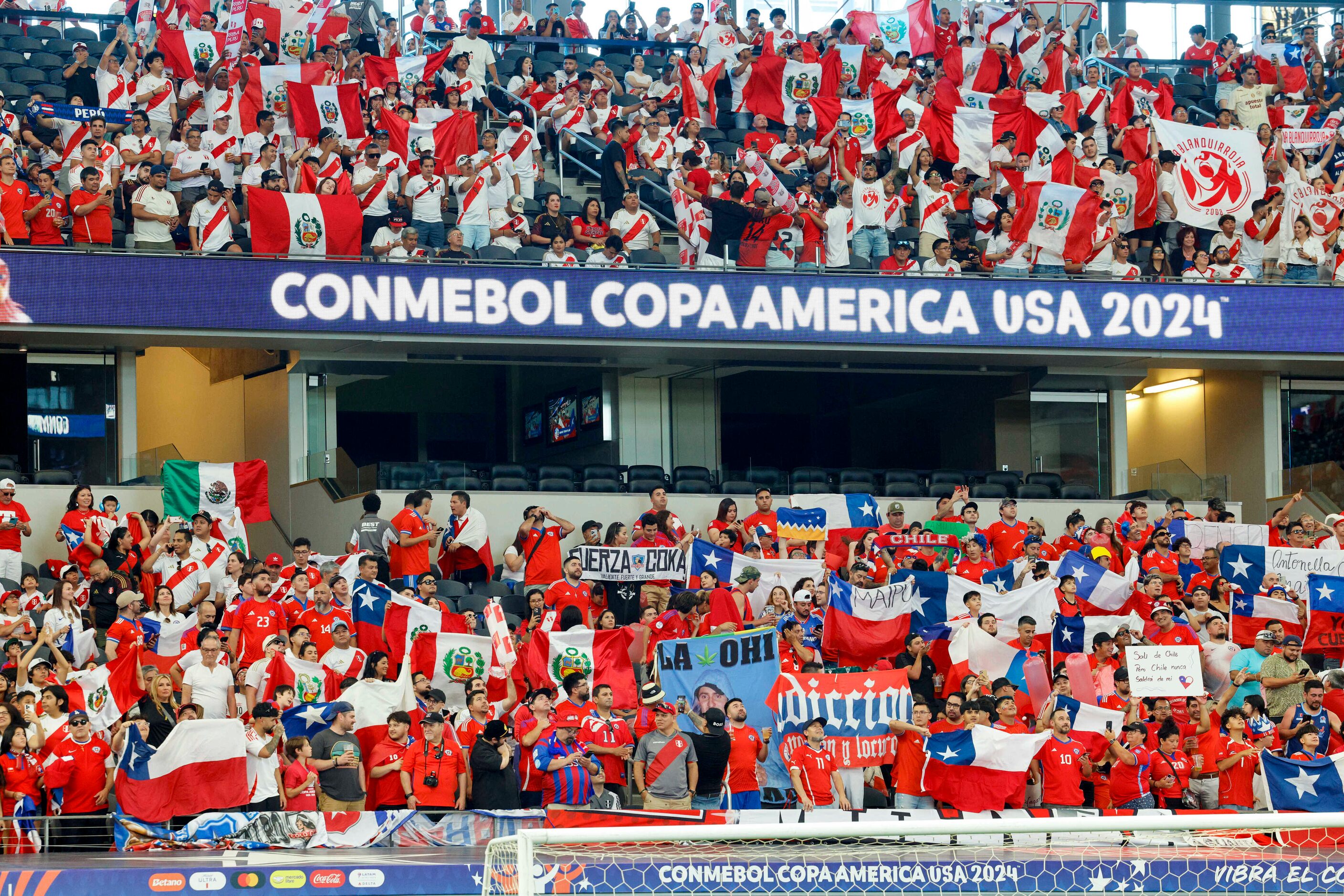 Chile and Peru soccer fans stand and cheer as the players take the field before a Copa...