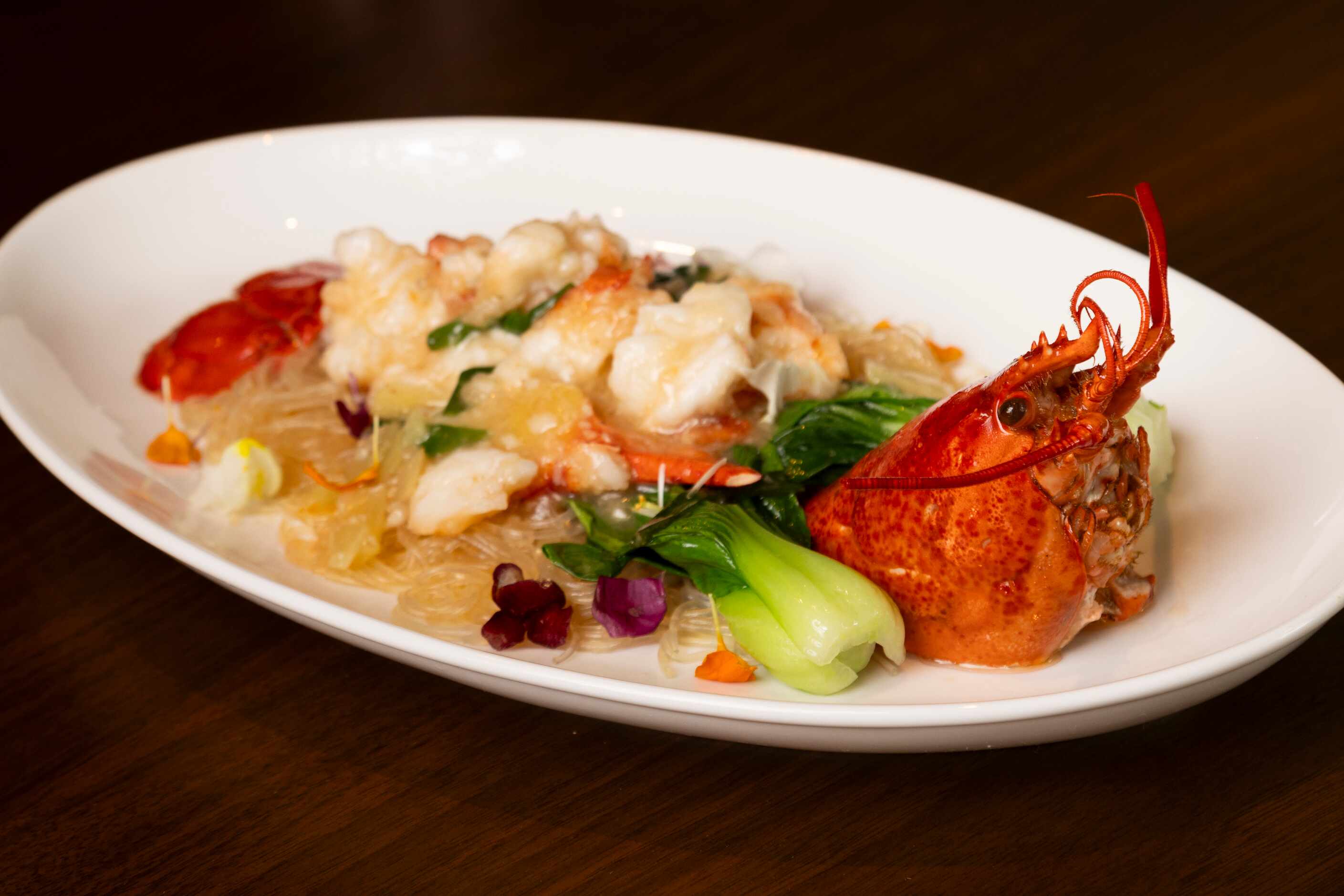 Live Maine Lobster with Shell-on sits atop glass vermicelli, hua diao wine, ginger and...