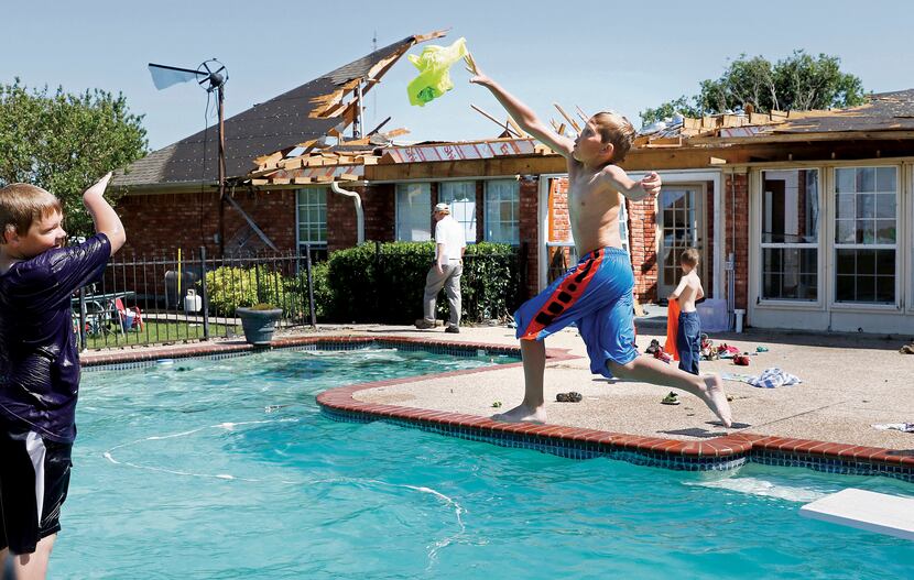 Jacob Campbell (left), 10, threw a wet T-shirt to Dax Foster, 10, as they swim at a home in...