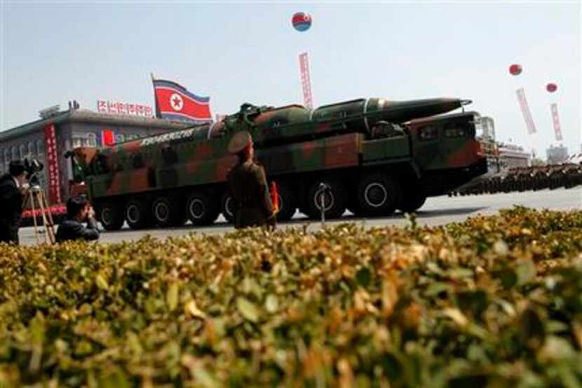 A North Korean vehicle carrying what appears to be a new missile passes by during a mass...