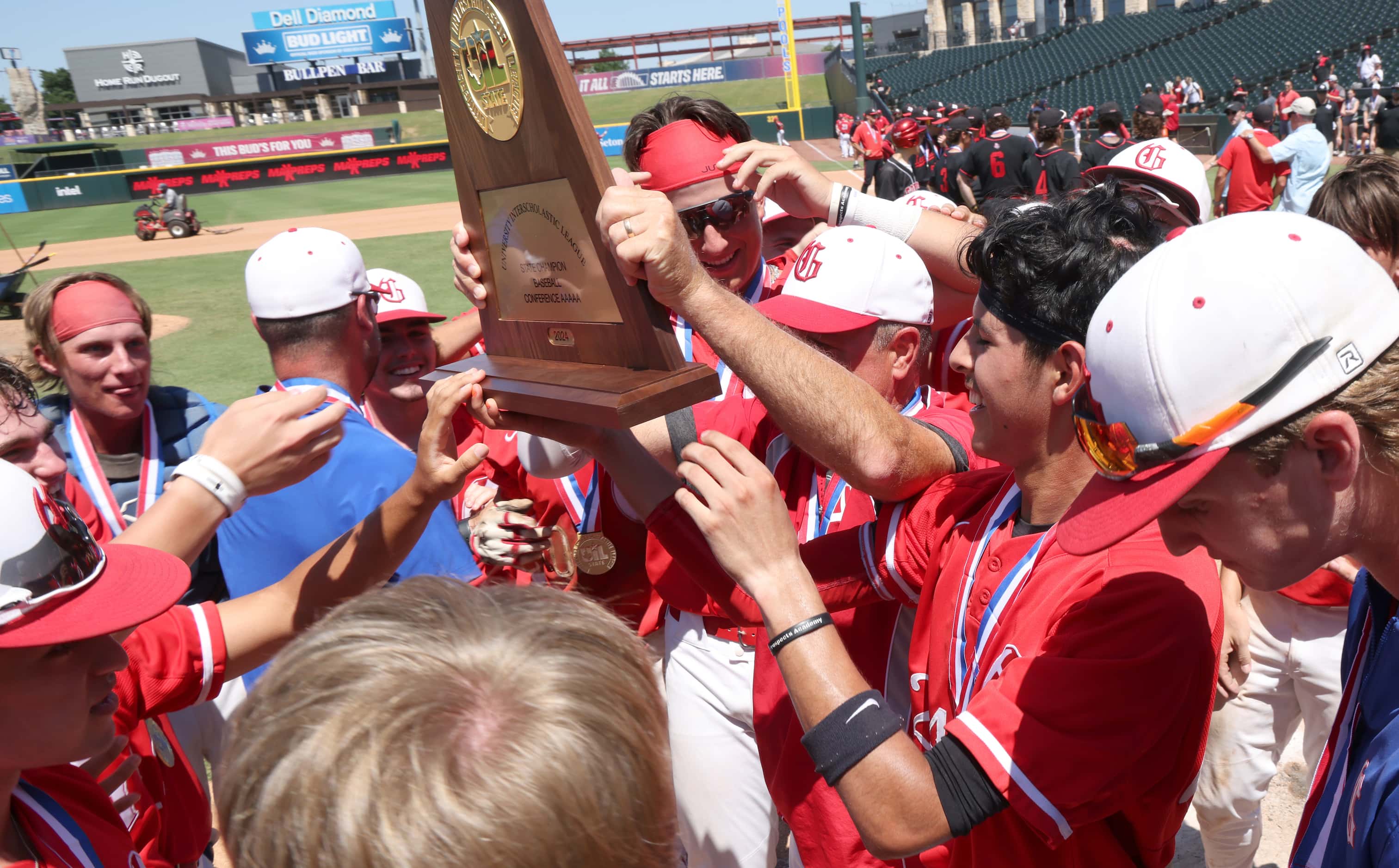 Grapevine players celebrate with head coach Jimmy Webster as he hoists the Class 5A state...