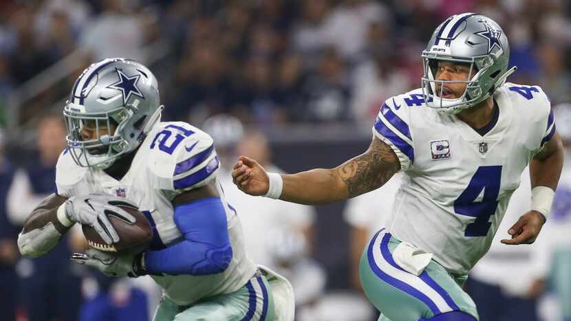 Dallas Cowboys quarterback Dak Prescott (4) hands off to running back Ezekiel Elliott (21)...