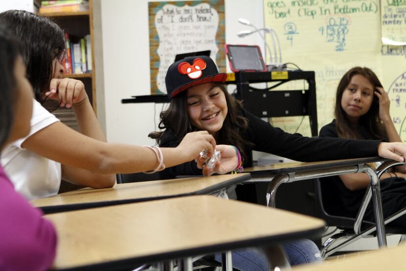 Student Sandy Salazar, center, passes a prop called a talking piece to classmate Joselyn...