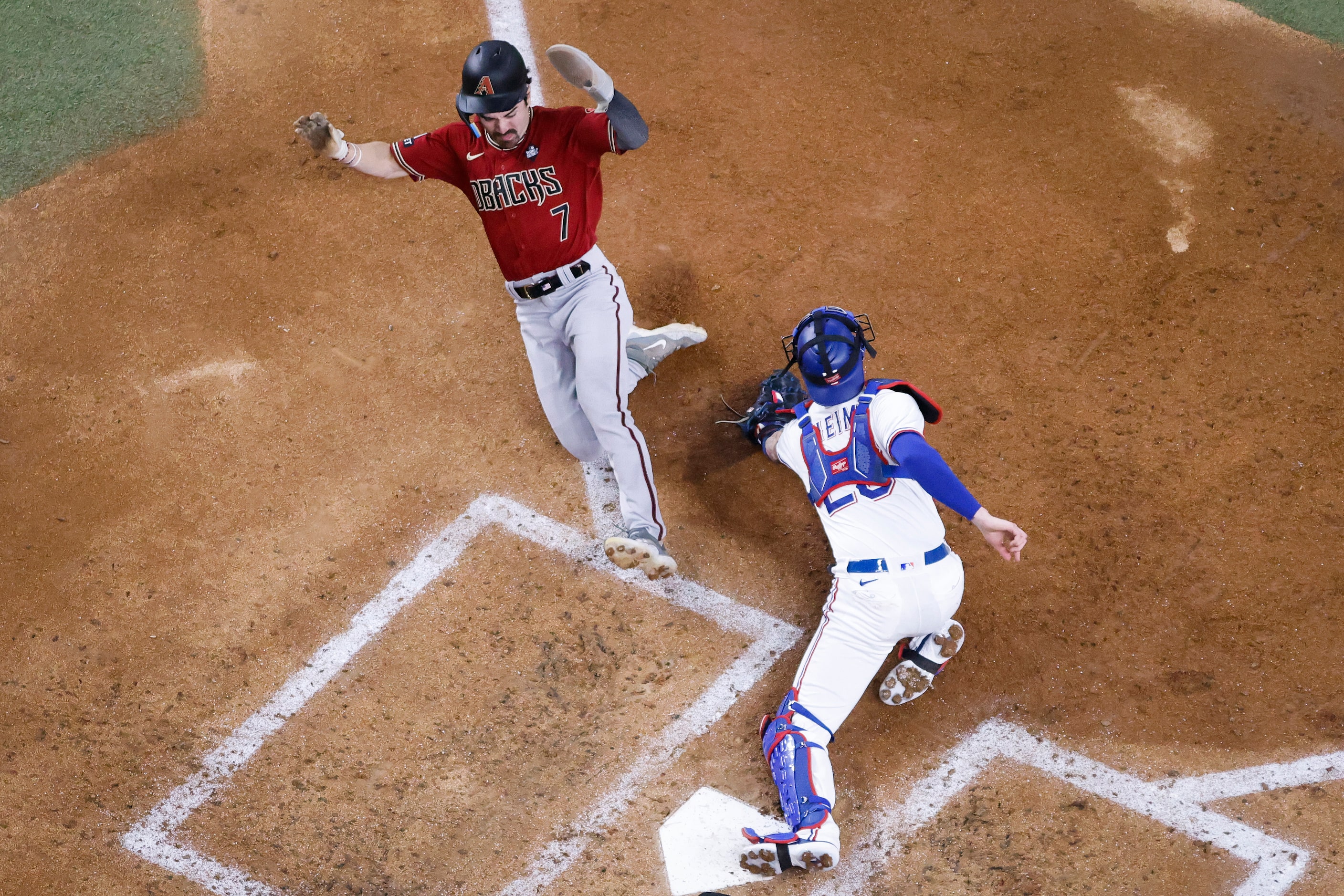 Arizona Diamondbacks' Corbin Carroll scores past Texas Rangers catcher Jonah Heim during the...