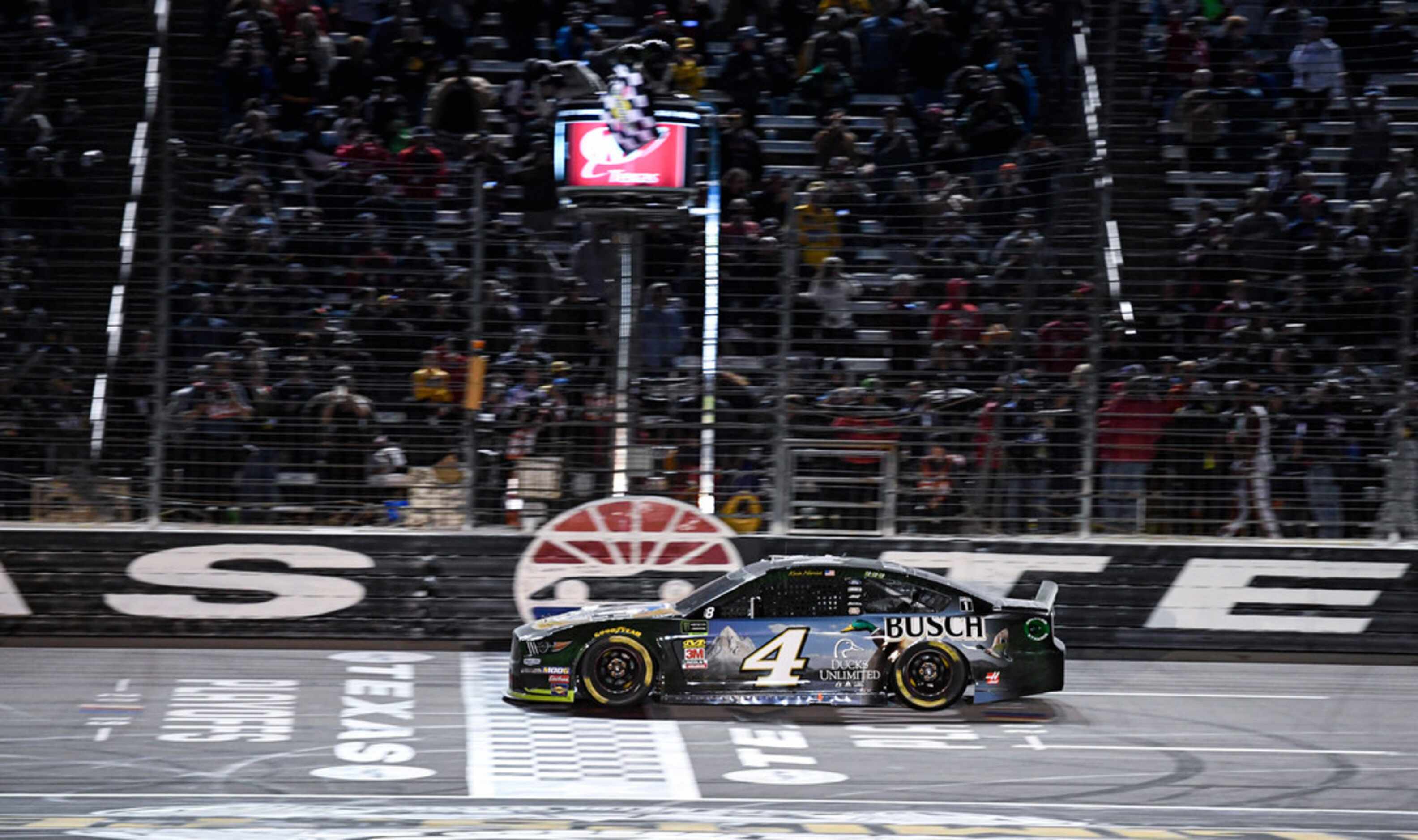 Kevin Harvick (4) crosses the finish line to win a NASCAR Cup Series auto race at Texas...