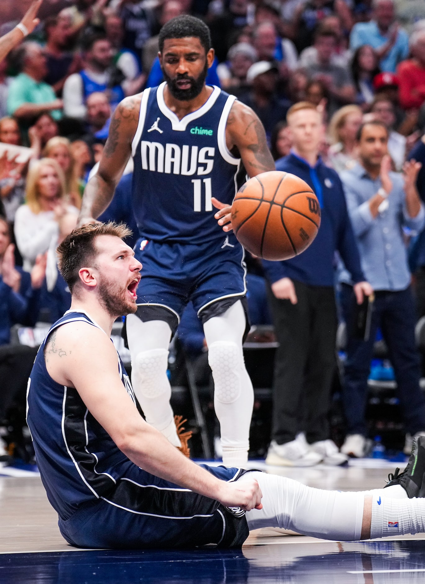 Dallas Mavericks guard Luka Doncic reacts as guard Kyrie Irving (11) looks on after being...