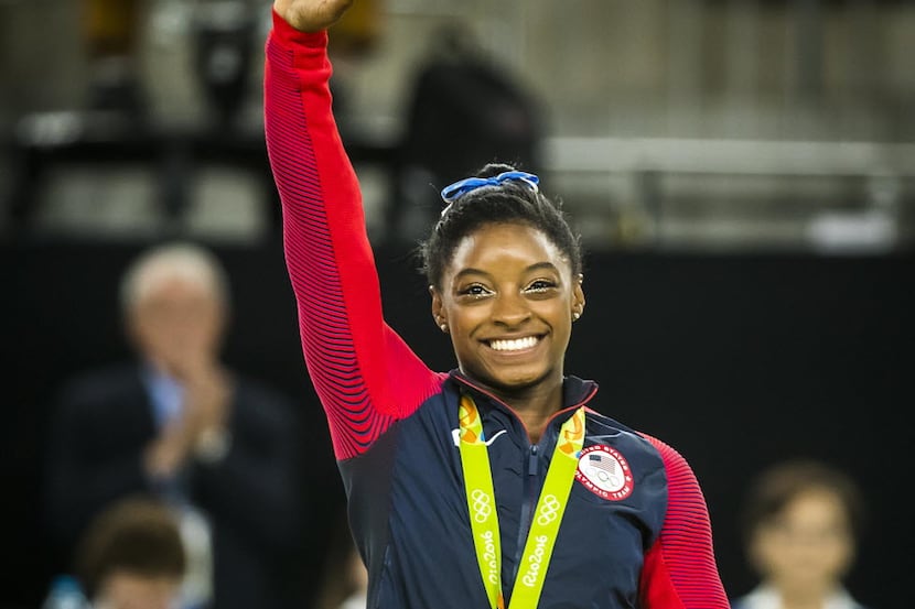 Simone Biles of the United States waves to the crowd after receiving her gold medal for the...