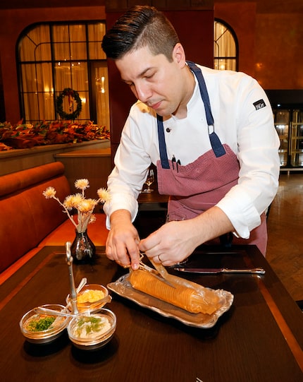 Executive Chef Antonio Votta cuts a bag of Ritz crackers to prepare an appetizer called Ritz...