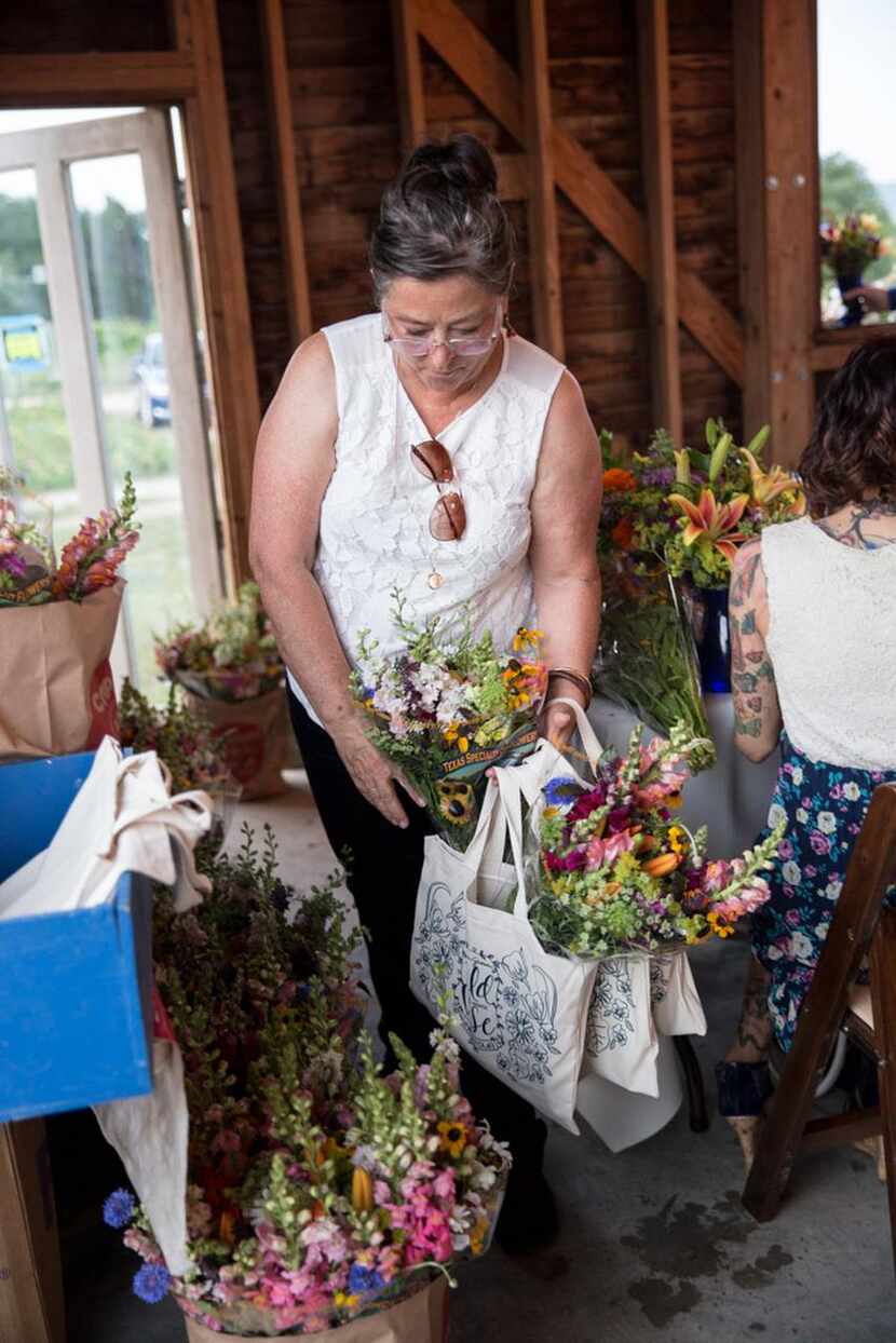 
A Field to Vase dinner guest collecting her parting swag bag and fresh cut flowers.
