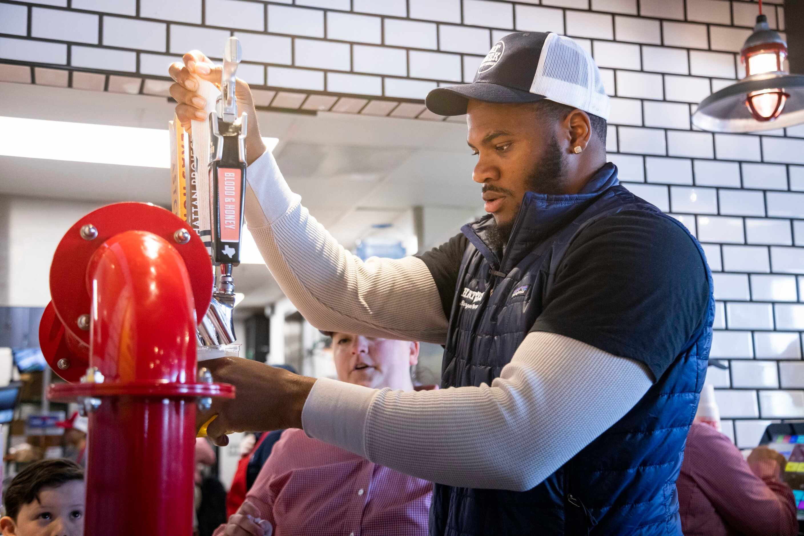 Dallas Cowboys linebacker Micah Parsons pours a beer on tap at Hat Creek Burger Company in...