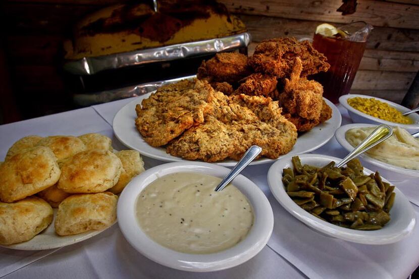 A family-style portion of chicken-fried steak and fried chicken is pictured with a plate of...