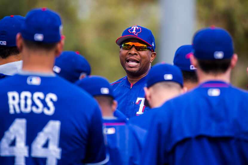 Texas Rangers third base coach Tony Beasley (27) gives instructions to players during a...
