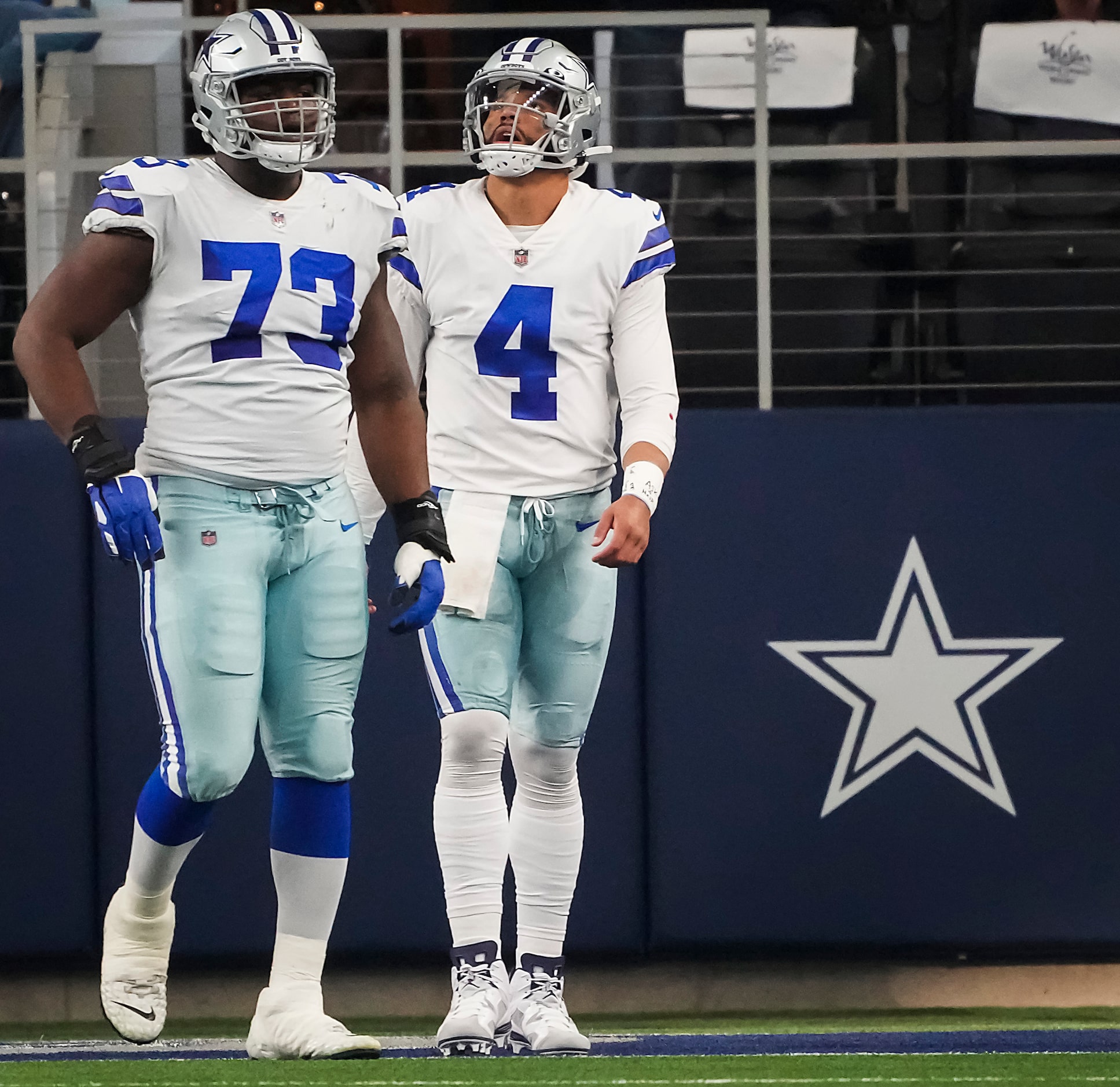 Dallas Cowboys quarterback Dak Prescott (4) and offensive tackle Tyler Smith (73) looks up...