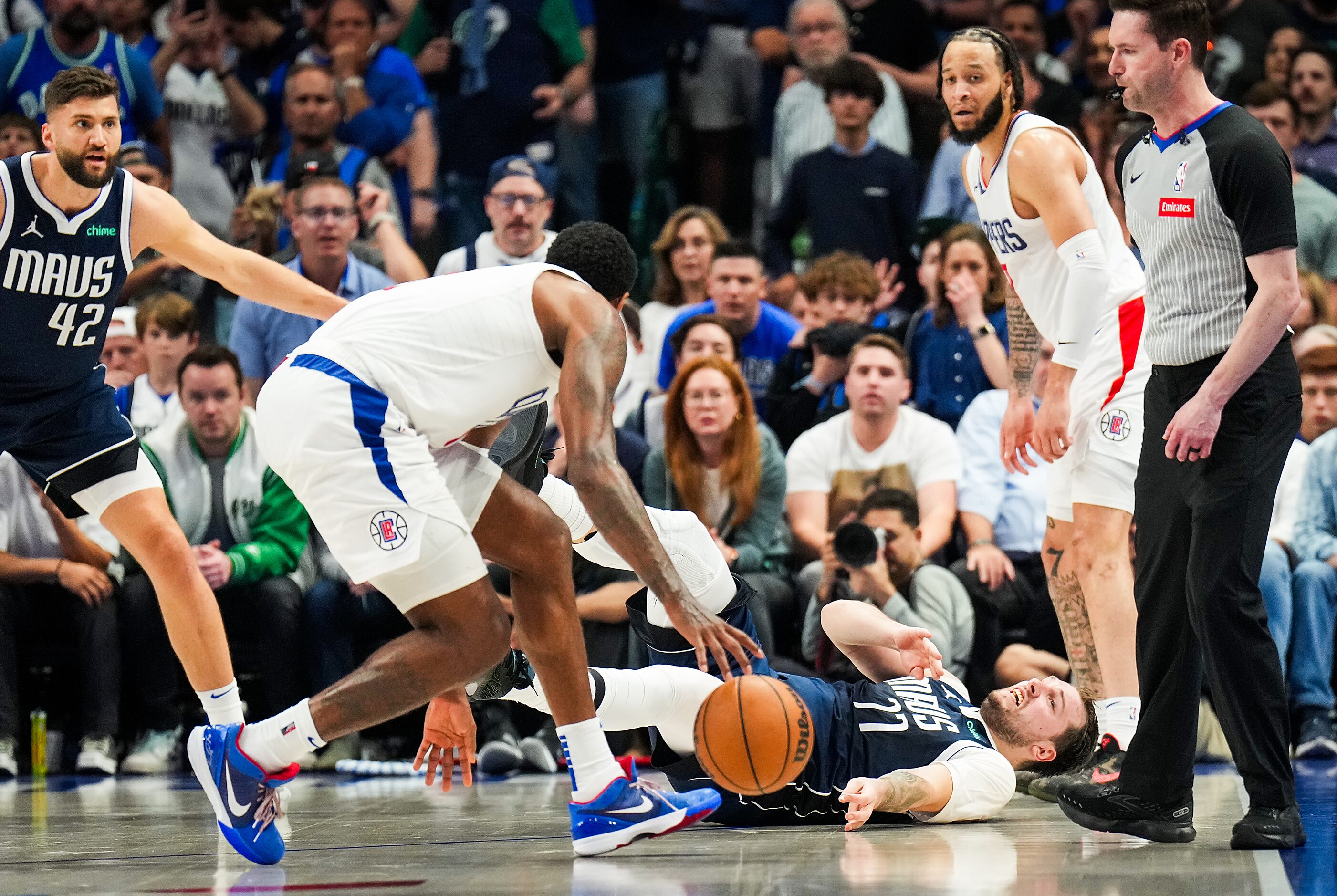 Dallas Mavericks guard Luka Doncic (77) falls to the floor as he collides with LA Clippers...