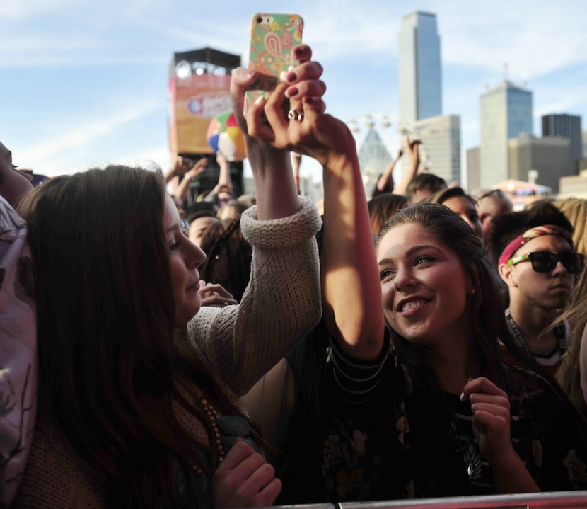 Maddey Thomson (left) and Grace Thomson dance while holding a phone while listening to the...