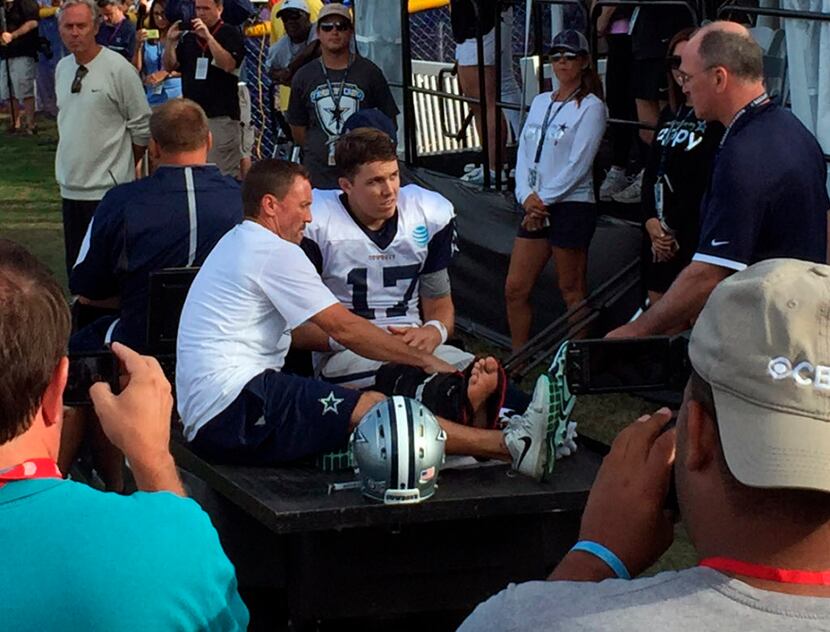 Dallas Cowboys quarterback Kellen Moore (17) listens to the doctor before being carted off...