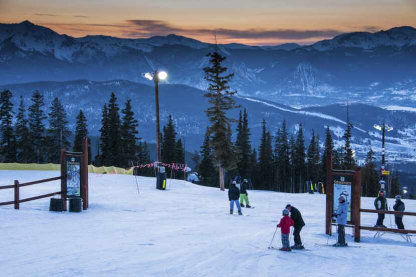 Skiers and snowboarders gather at the the Schoolmarm trail at dusk on Dercum Mountain.