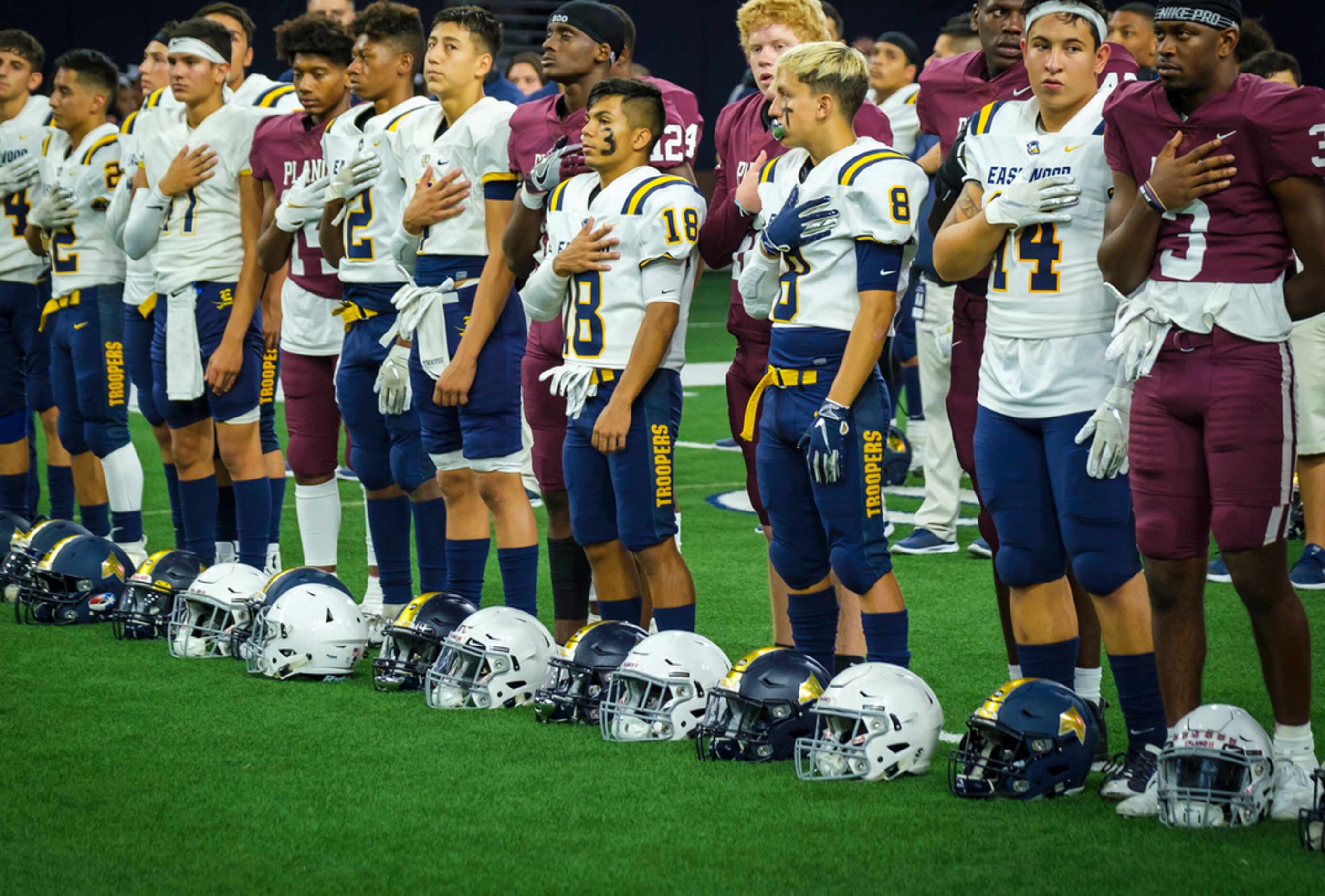 Plano and El Paso Eastwood High School players stand for the national anthem at midfield...