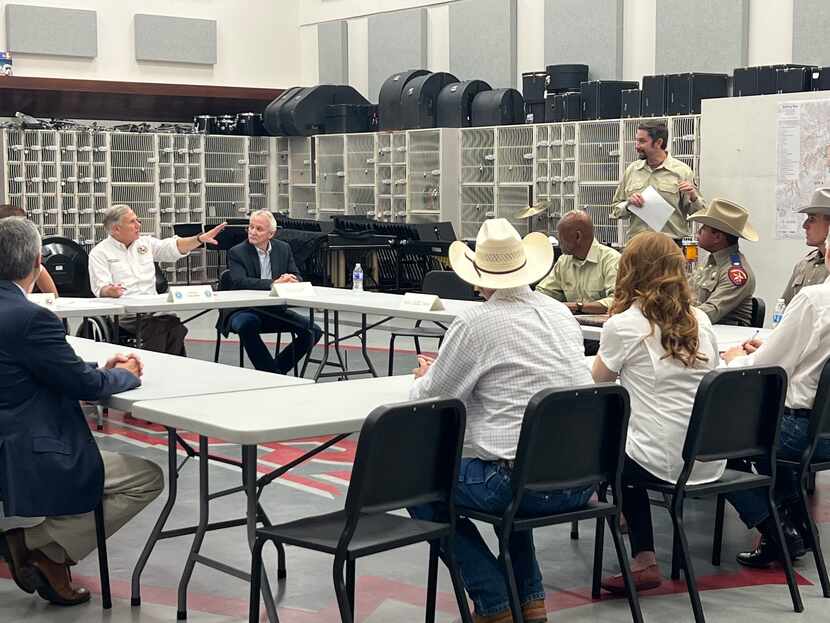 Gov. Greg Abbott receives a briefing on Texas' wildfire response Saturday in Glen Rose.
