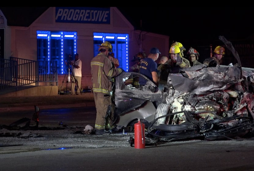 Rescue workers look over what's left of a Dodge Charger after hit hit a DART bus from behind...