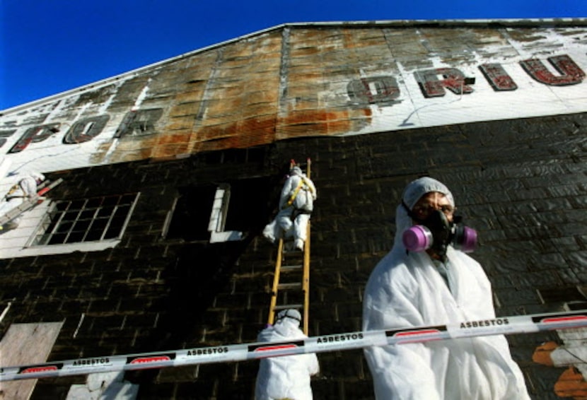 Pedro Enriquez (right) and other workers from L.A. Environmental Inc. stripped...