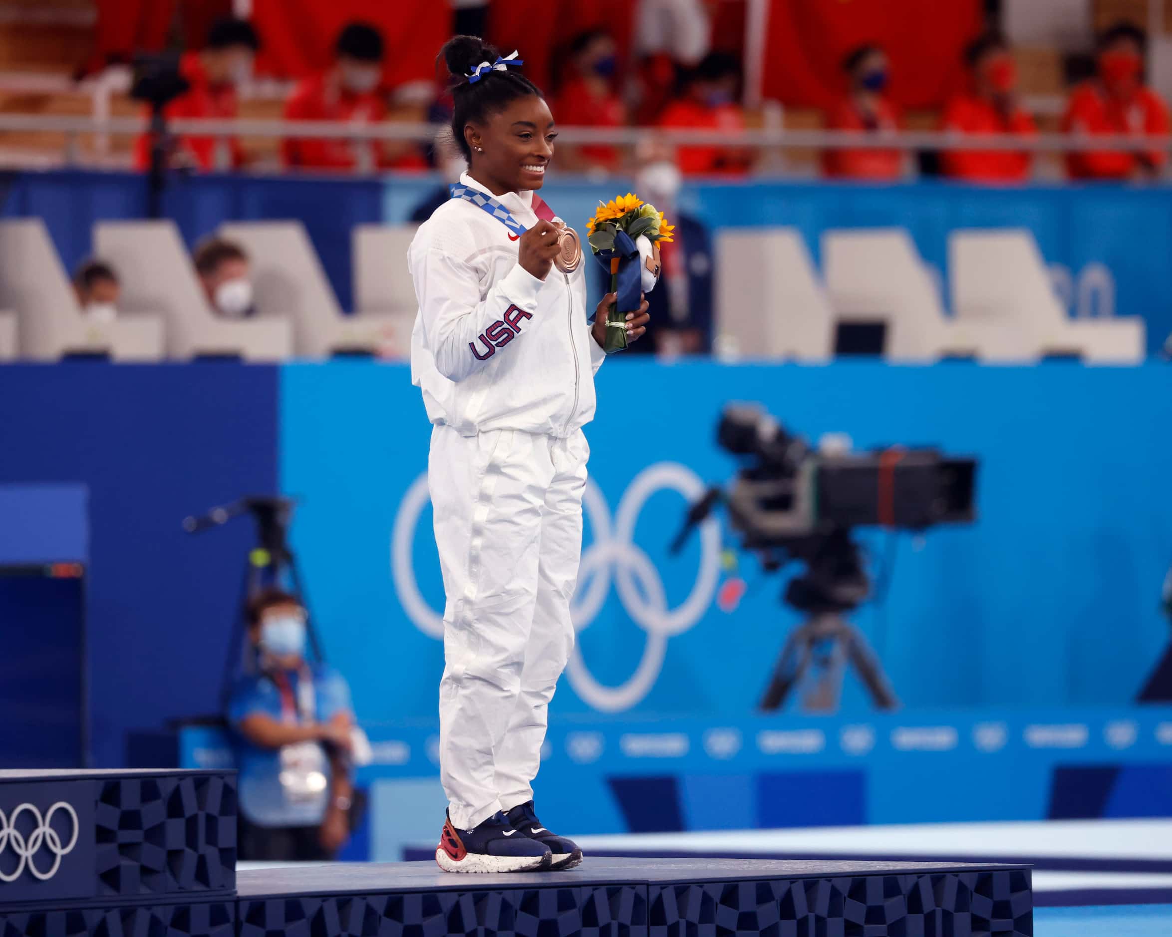 USA’s Simone Biles poses for photos with her bronze medal during the medal ceremony for the...