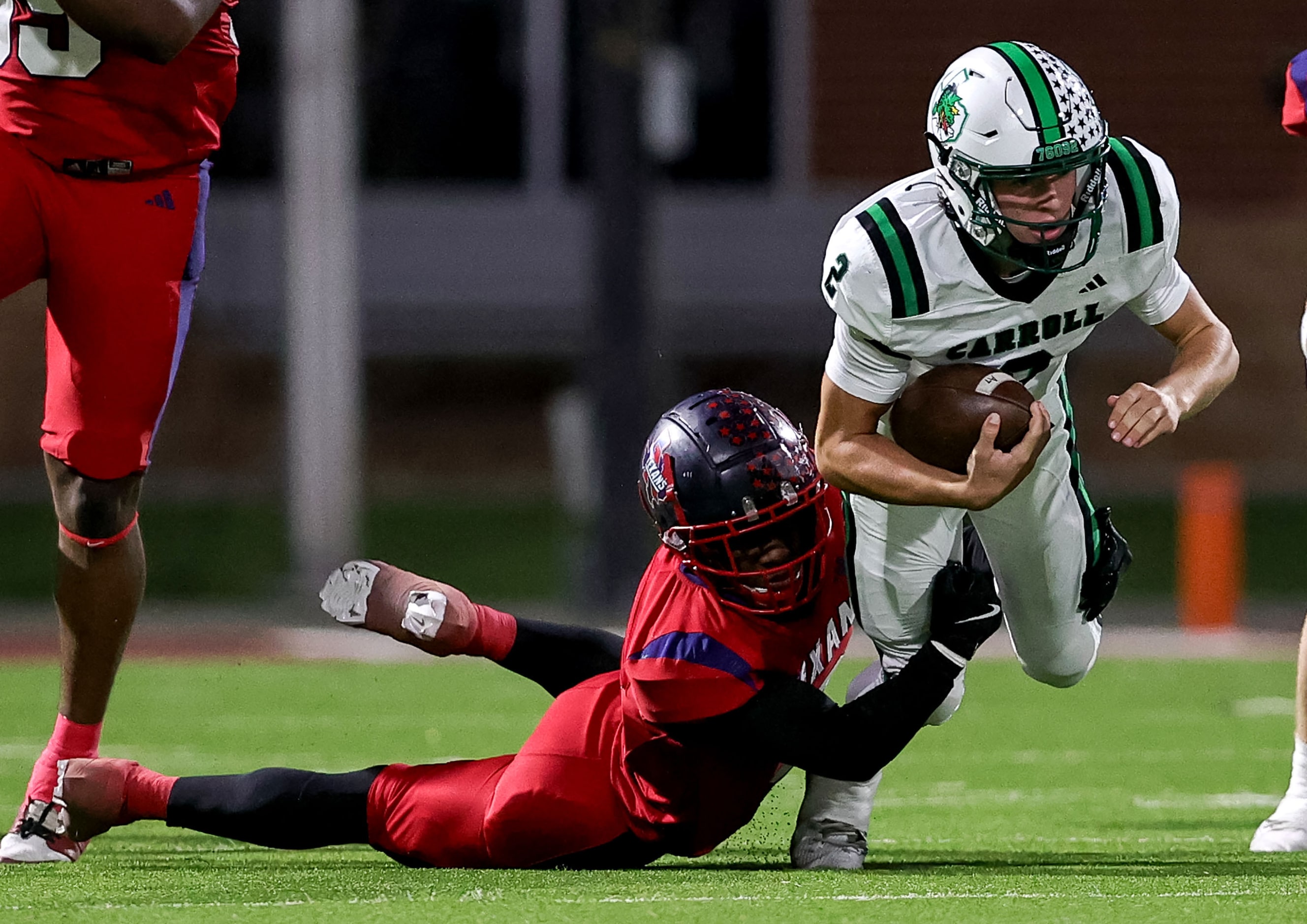 Southlake Carroll quarterback Angelo Renda (2) is stopped by Justin Northwwest defensive...