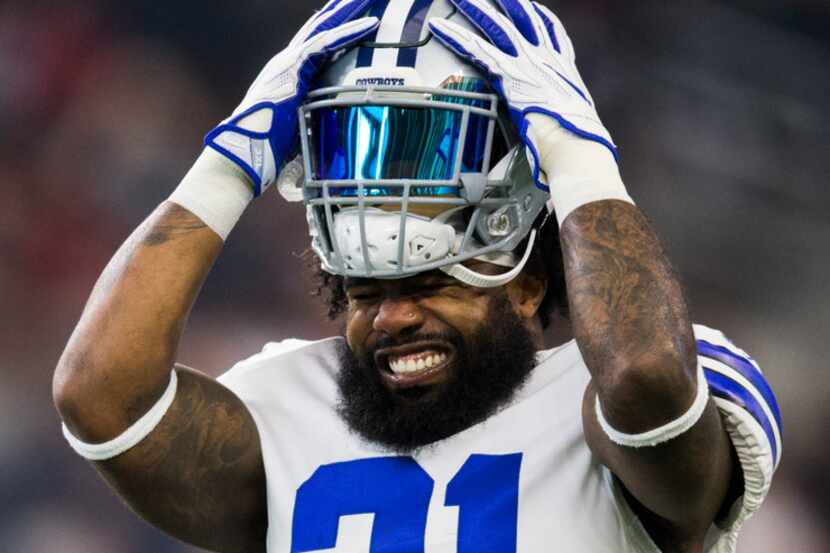 Dallas Cowboys running back Ezekiel Elliott (21) jams his helmet over his hair during...