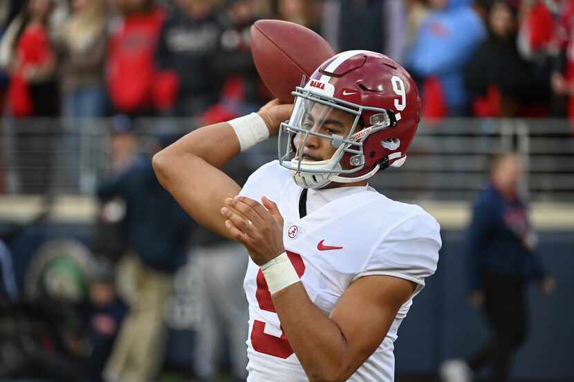 FILE - Alabama quarterback Bryce Young (9) warms up on the sidelines during the first half...