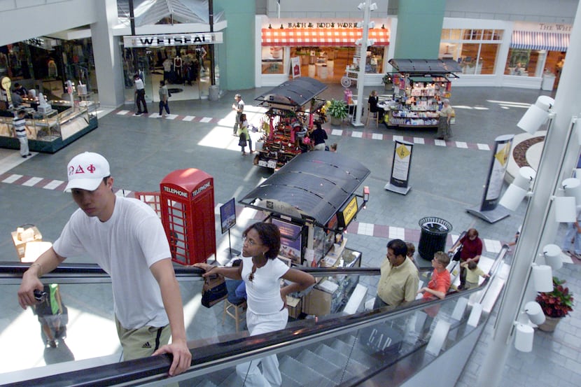 Shoppers ride the escalator at The Parks Mall in Arlington.