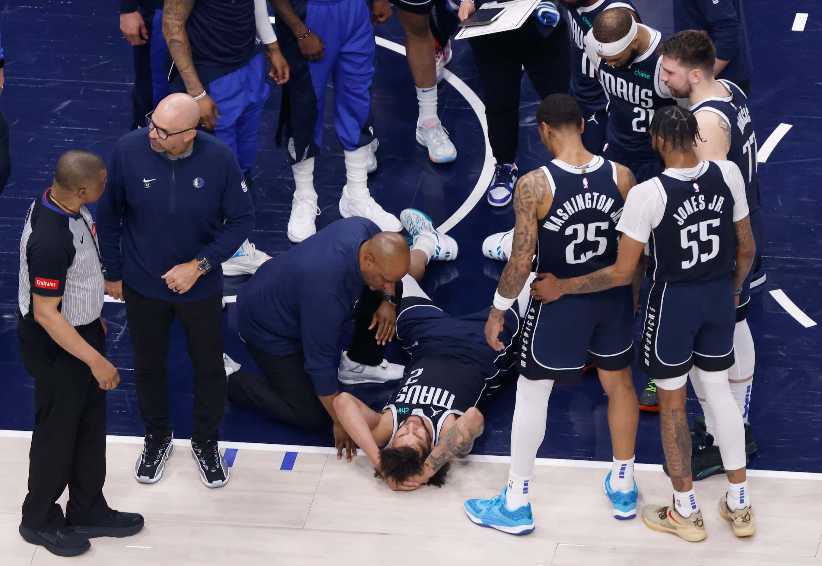 Dallas Mavericks center Dereck Lively II (2) holds his head after sustaining an injury...