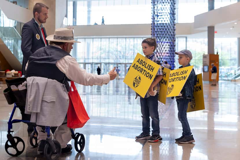 Brothers Jesse Youngblood, 9, and Peter Youngblood, 7, of Austin receive a thumbs up from an...