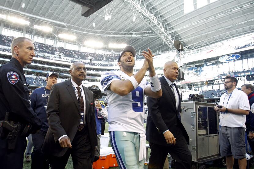 Dallas Cowboys quarterback Tony Romo (9) smiles as he exits the field in a game against the...