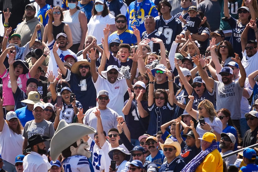 Dallas Cowboys fans cheer at the direction of team mascot Rowdy during a joint practice with...