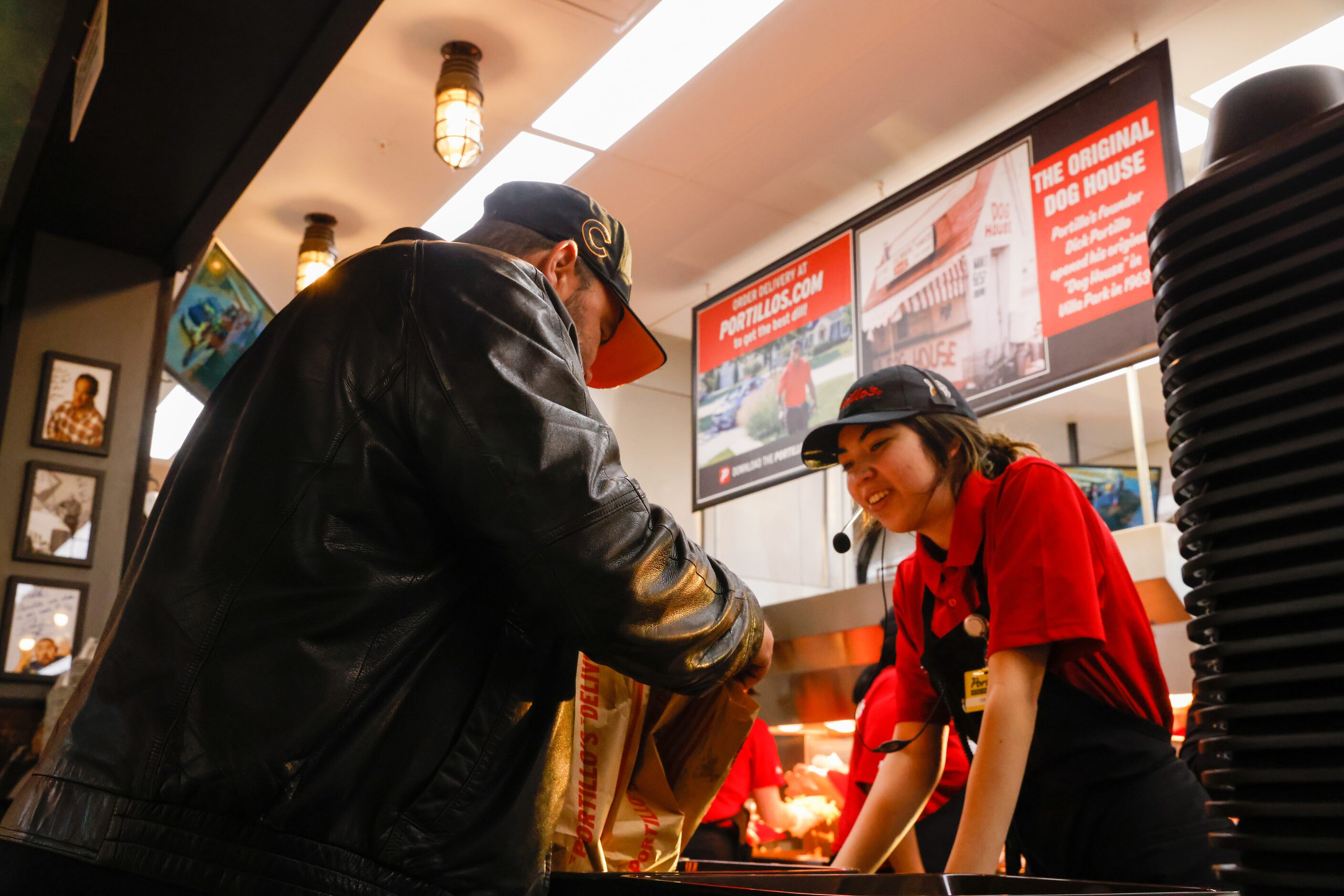 Ely Martinez collects his order from Portillo’s crew member Hannya Deleon at the new...