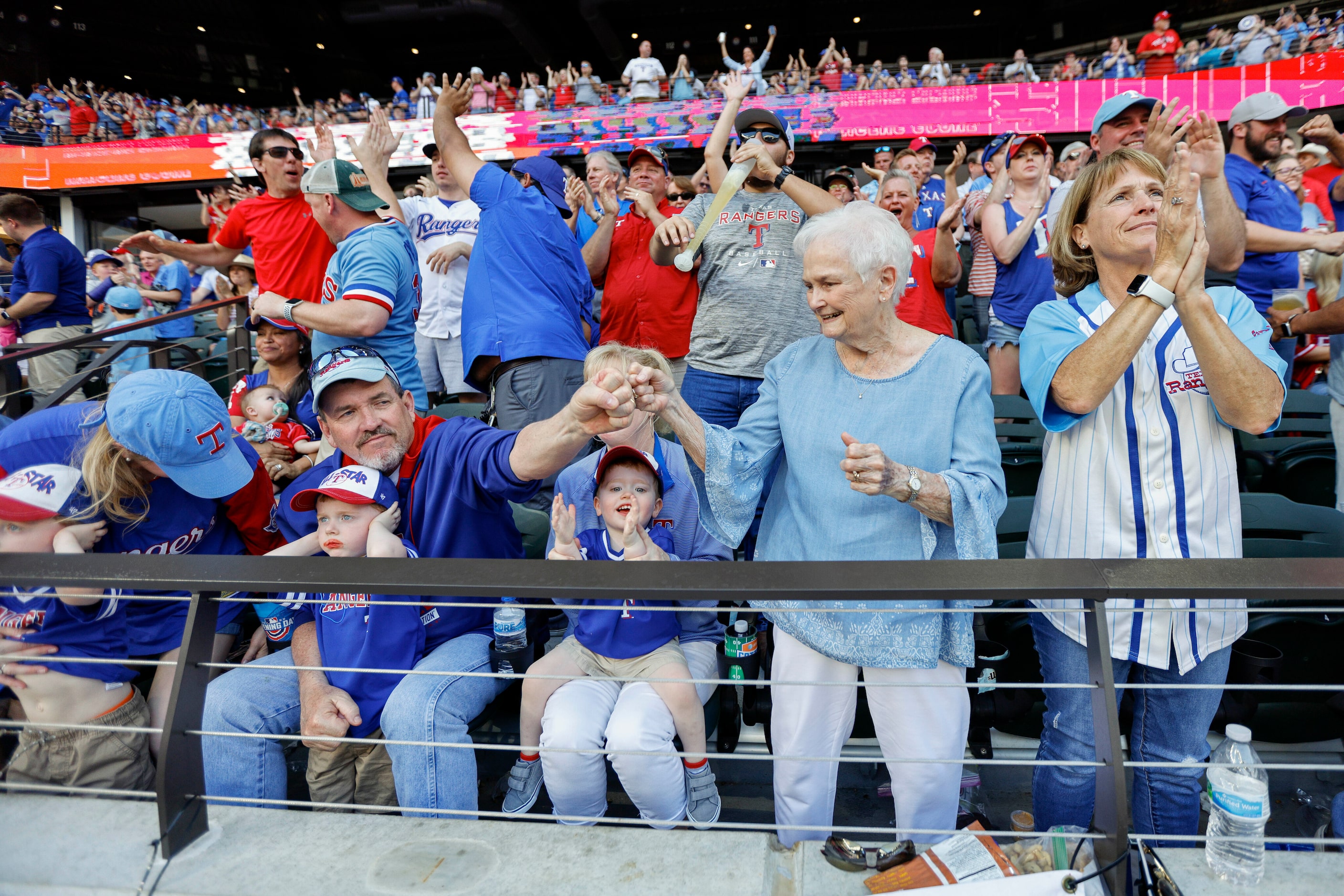 Nancy Wangner ( second from right) celebrates a pair of runs by the Texas Rangers with her...