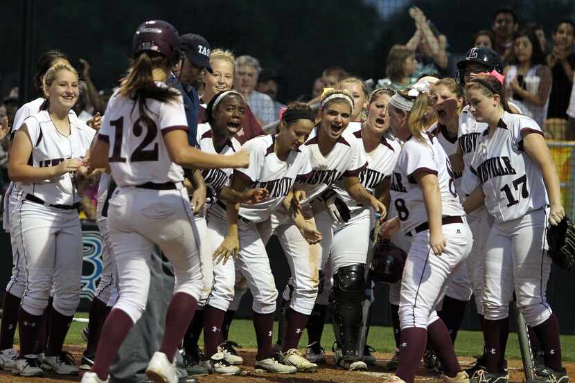Lewisville's Maribeth Gorsuch (12) is greeted at home plate by teammates after hitting a...
