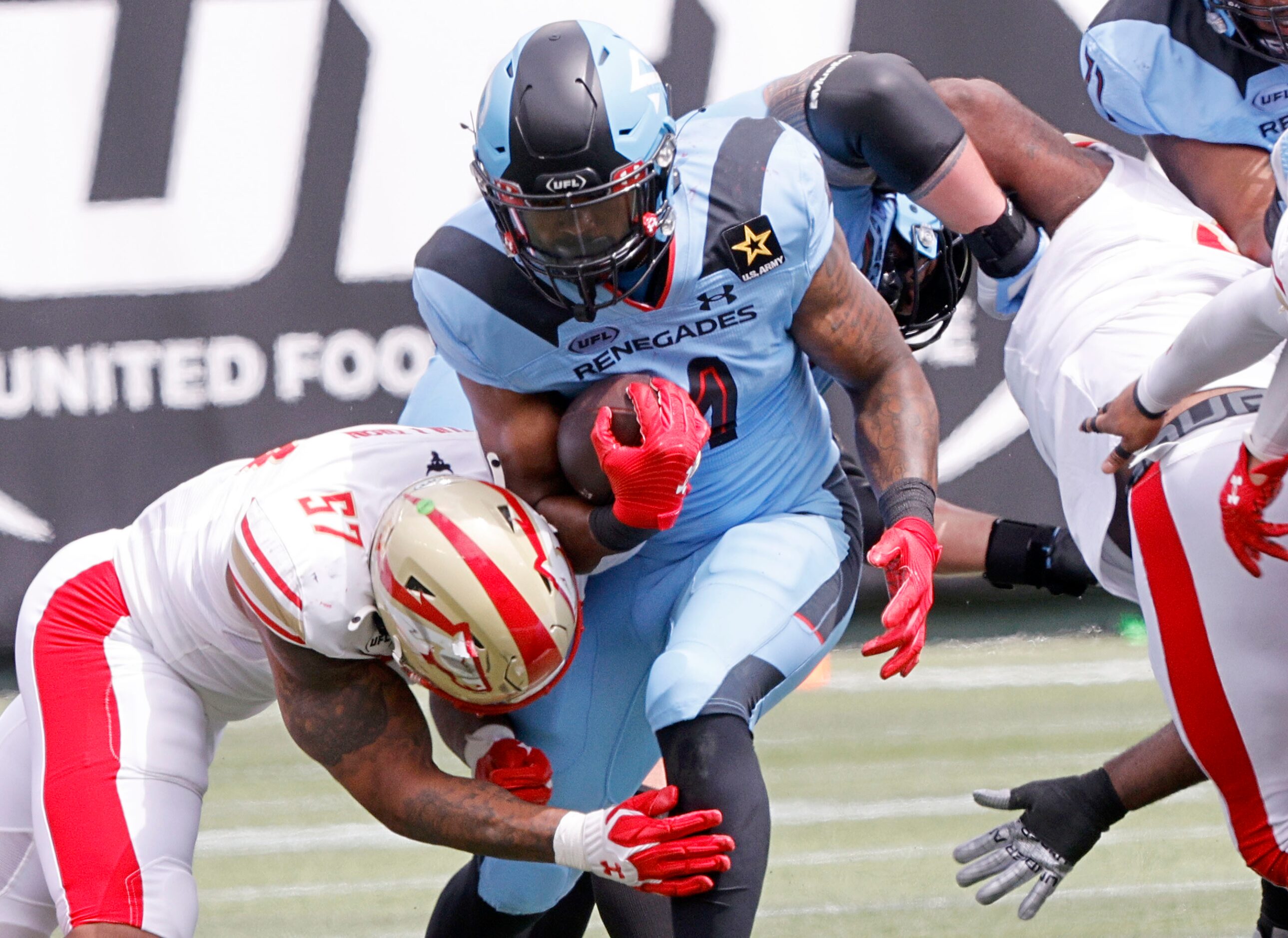 Arlington Renegades running back Leddie Brown (4), center, is tackled by Birmingham...