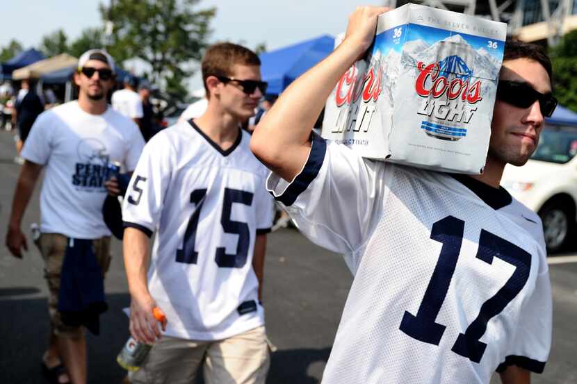 STATE COLLEGE, PA - SEPTEMBER 01: Penn State tailgaters walks with beer in the parking lot...